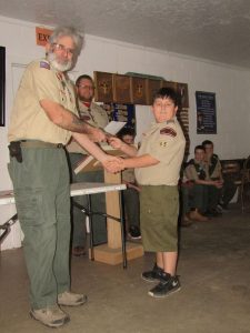 boy shakes hands when receiving badges