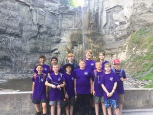 Boys pose by waterfall